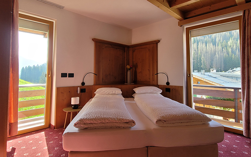 Swiss pine double room at Garni Royal in Arabba with balcony and Dolomite view.