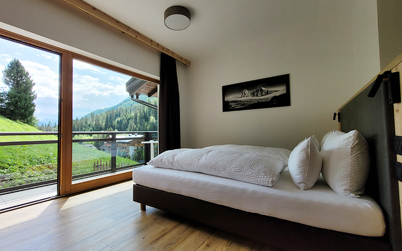 Double room at Garni Royal with balcony and panoramic view of the Dolomites and the Arabba valley.