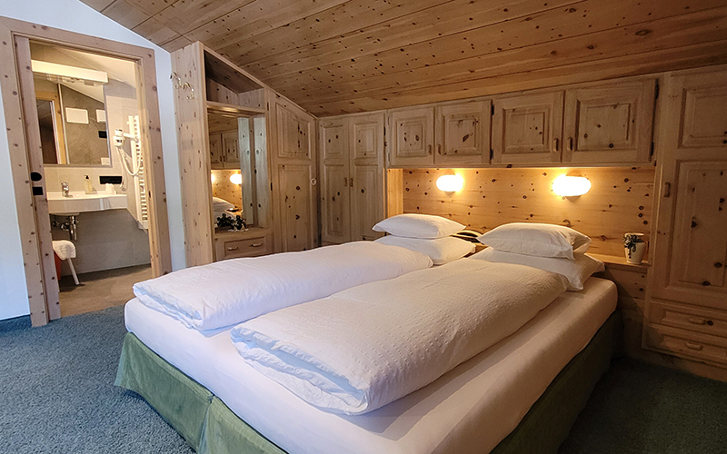 Swiss pine double room at Garni Royal in Arabba, with private bathroom and typical Dolomites furnishings.
