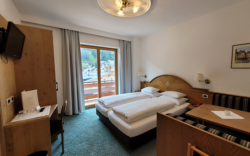 Double room at Garni Royal in Arabba with single beds, private balcony, and view of the Dolomites.