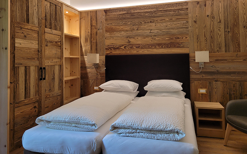 Double or twin room at Garni Royal in Arabba, with Swiss pine wood furnishings and single beds.